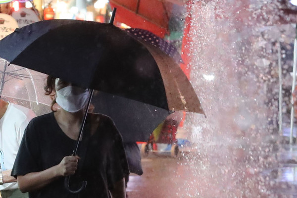 출처 = 뉴시스 / 비가 내리고 있는 8일 오후 서울 강동구 둔촌역 전통시장에서 시민들이 우산을 쓰고 이동하고 있다